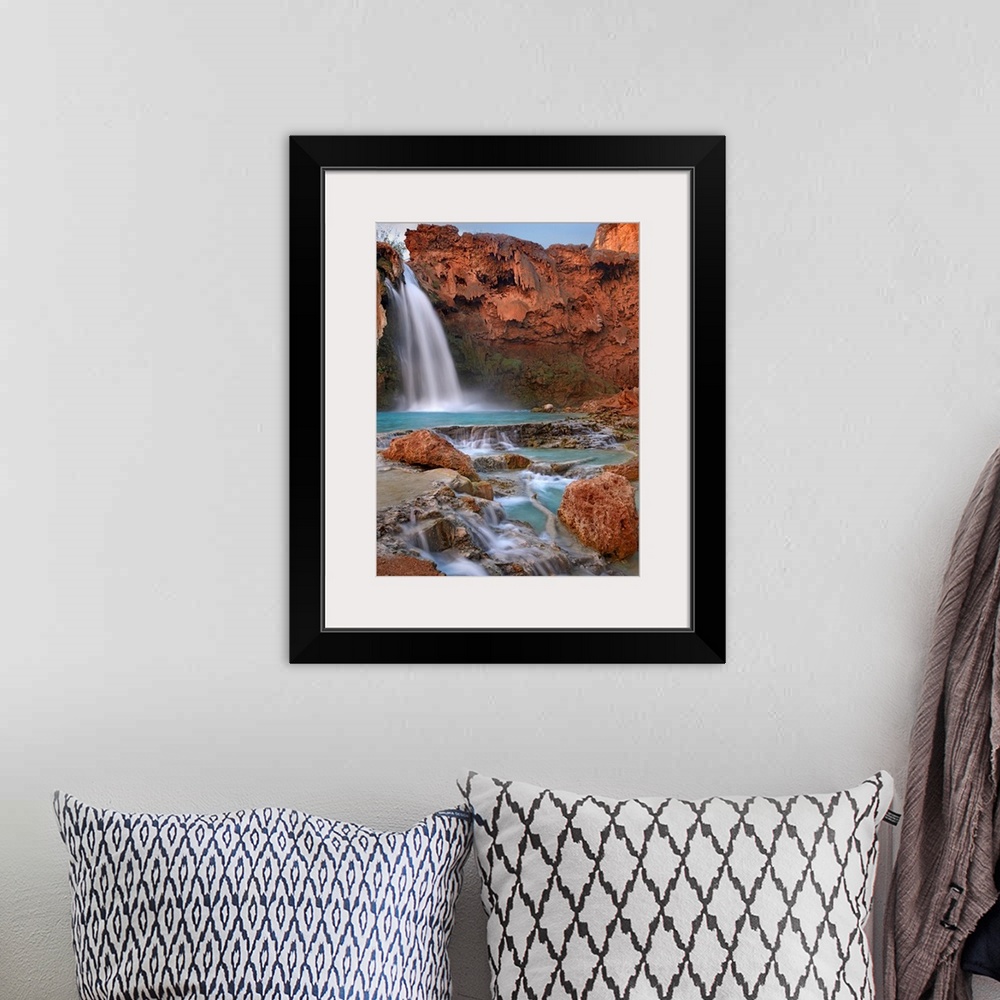A bohemian room featuring Large photograph showcases water falling down a jagged cliff and splashing into the pool below be...