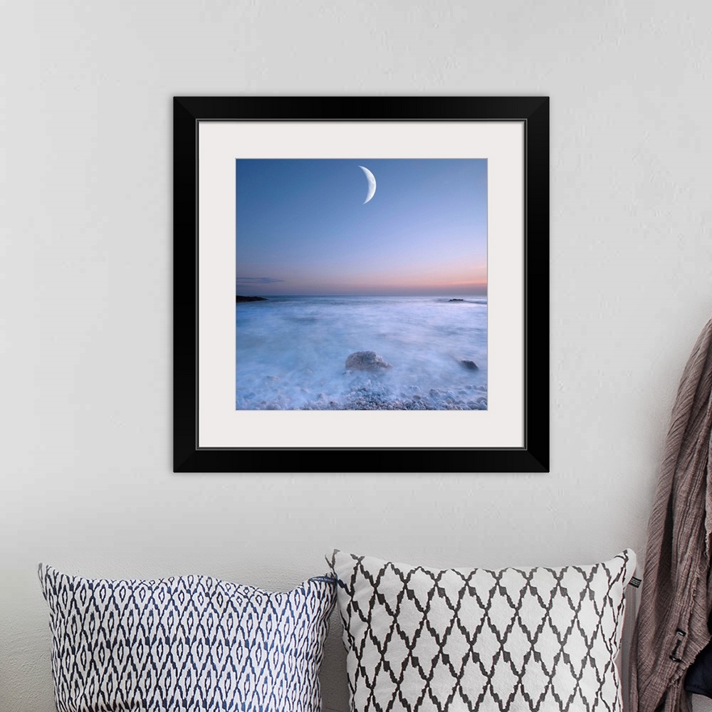A bohemian room featuring This large art piece highlights a crescent moon with fog cascading over the rocks and water below.