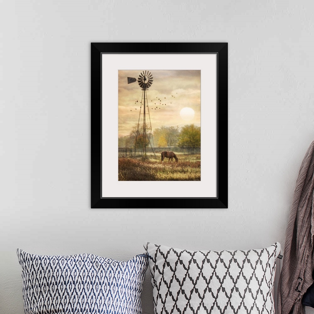 A bohemian room featuring Horse grazing in a field beside a windmill at sunrise.