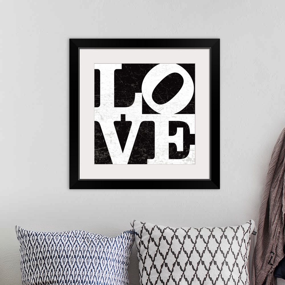 A bohemian room featuring A LOVE graphic with bold and distressed typography in black.