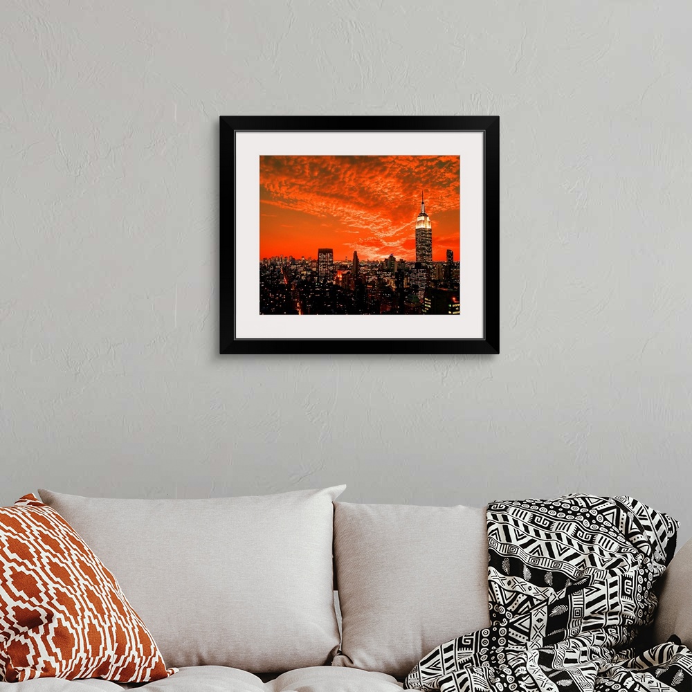 A bohemian room featuring The New York City midtown skyline under dramatic clouds.