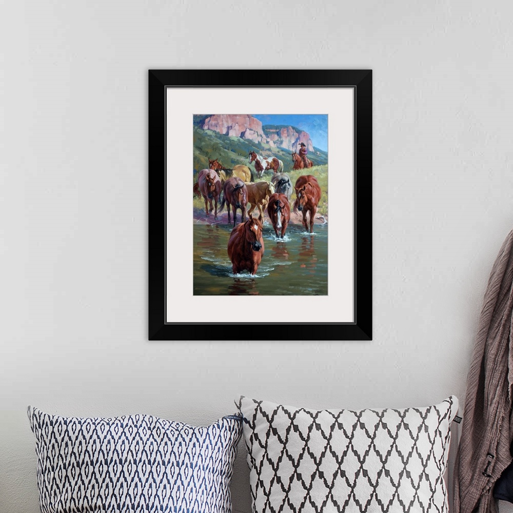 A bohemian room featuring Contemporary Western artwork of a herd of wild horses forging a river, being herded by a cowboy.
