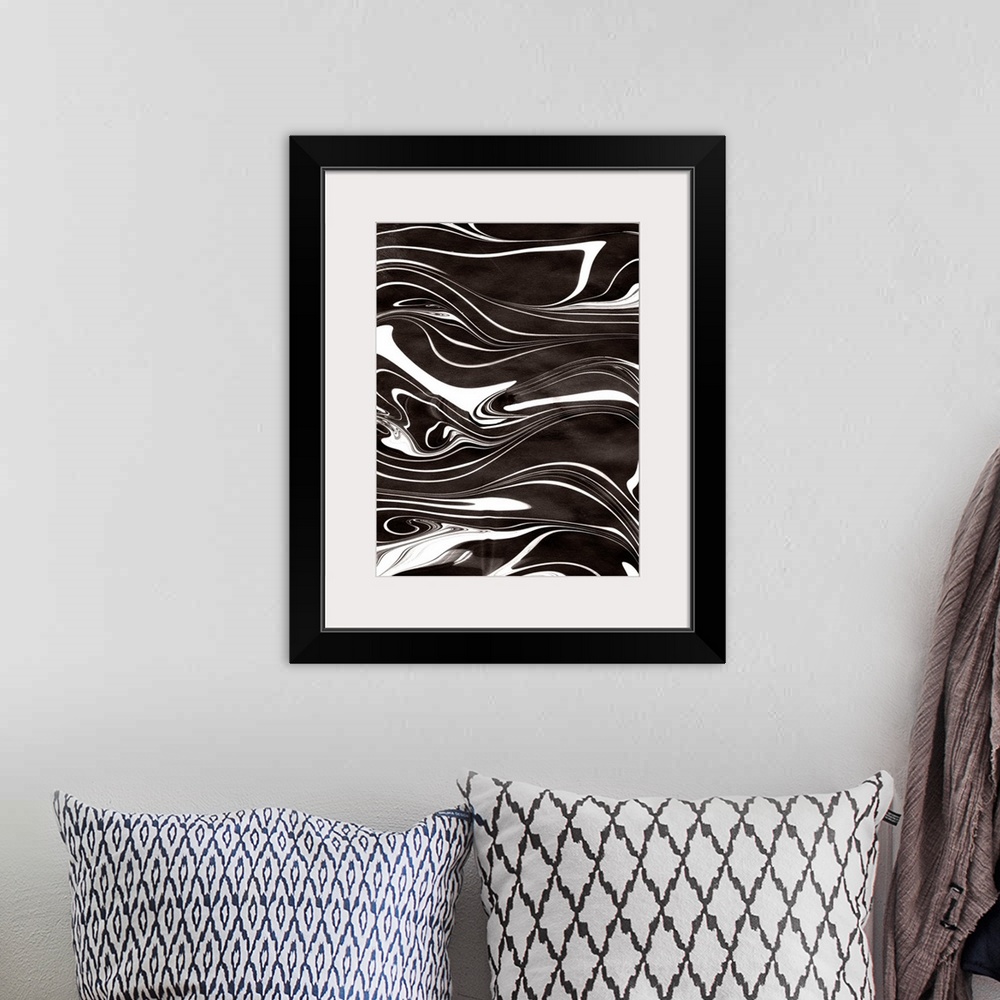 A bohemian room featuring Abstract artwork of black and white paint swirled around in rippling patterns.