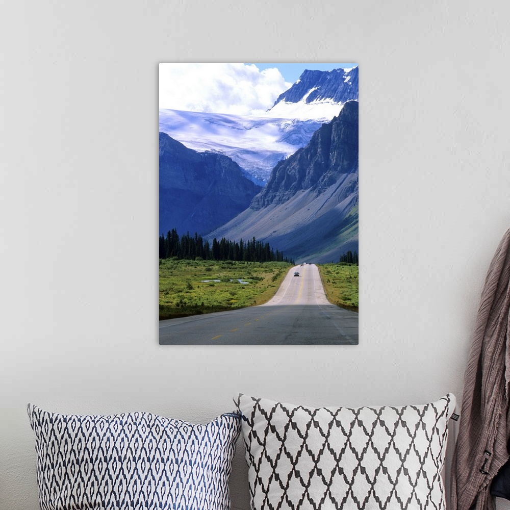 A bohemian room featuring A road into the mountains of Banff National Park, where fierce clouds and snowcapped peaks loom i...