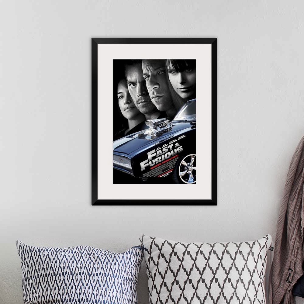 A bohemian room featuring Large, vertical movie advertisement for the Fast & Furious 4.  A muscle car in the foreground wit...