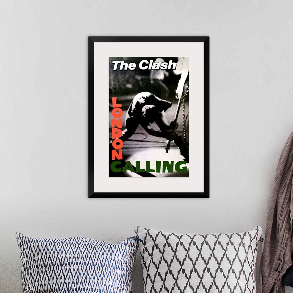 A bohemian room featuring Vertical, oversized black and white photograph of a band member of The Clash swinging a guitar to...