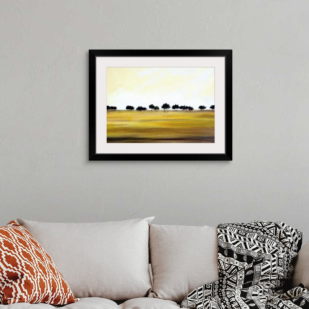 A bohemian room featuring Contemporary minimalist painting of a row of dark trees in the distance and golden fields in the ...