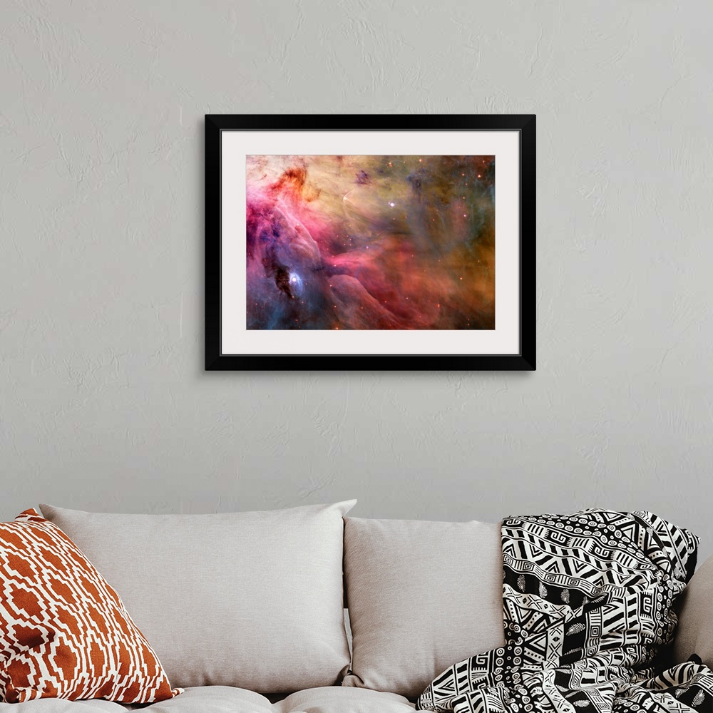 A bohemian room featuring Big canvas decor of a multicolored nebula with stars sprinkled around.
