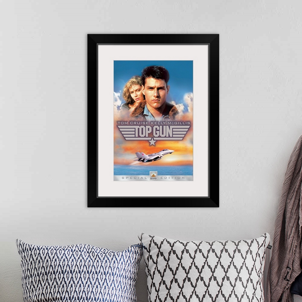 A bohemian room featuring Movie poster for Top Gun with Tom Cruise and Kelly McGillis in the sky as a military plane takes ...