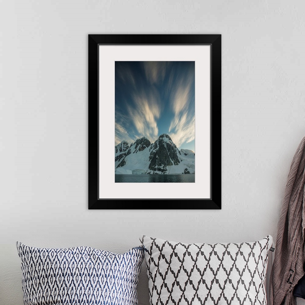 A bohemian room featuring Clouds rushing by overhead of snowy mountain scape.