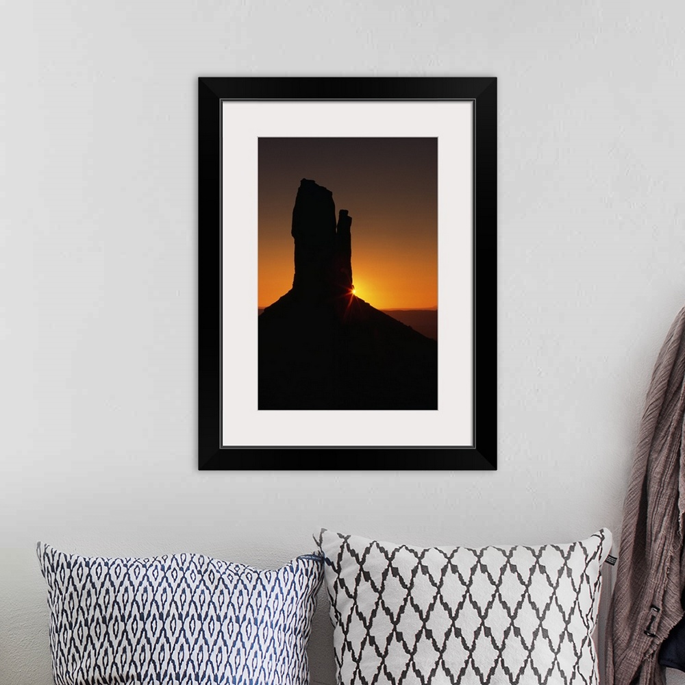 A bohemian room featuring Sunrise behind silhouetted sandstone formation, Monument Valley, Utah