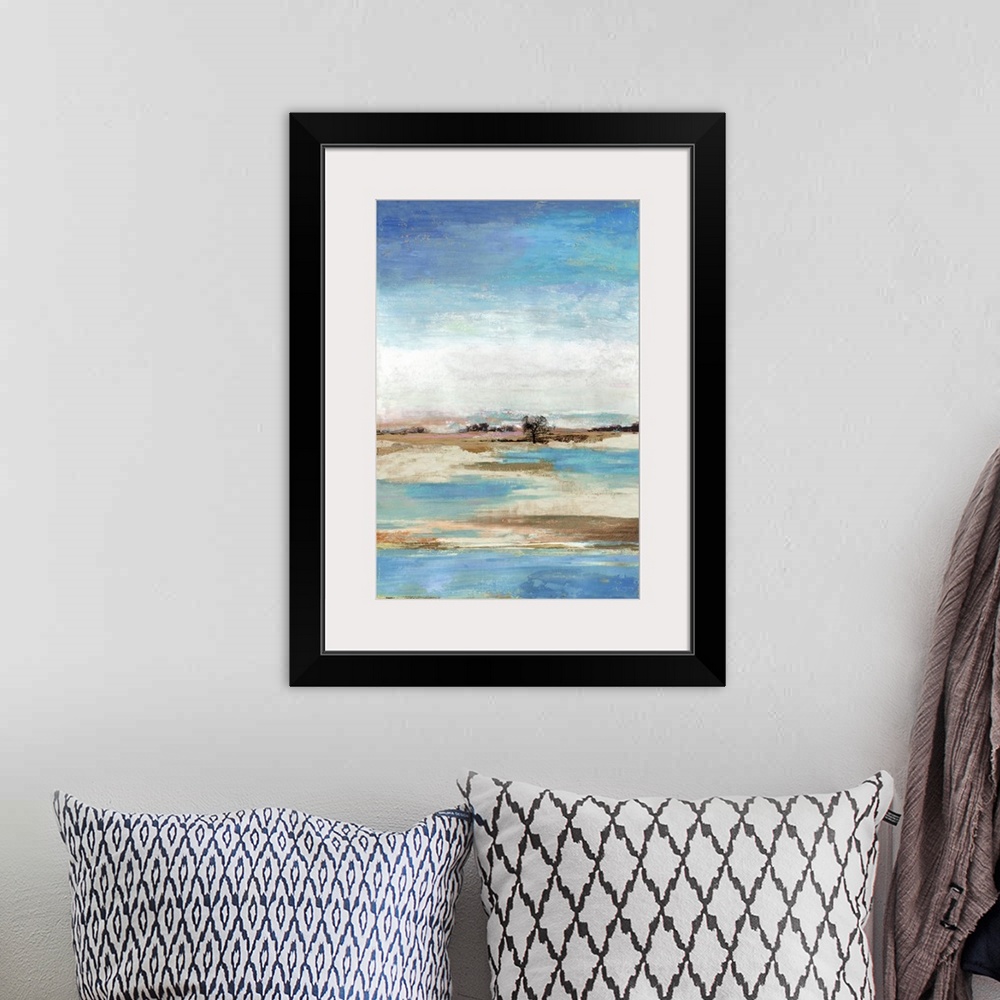 A bohemian room featuring Vertical artwork of an abstract landscape about a waterfront with blue skies.