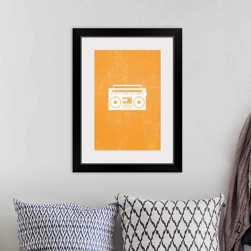 A bohemian room featuring Retro artwork that has a silhouette of a boom box against a bright orange background.