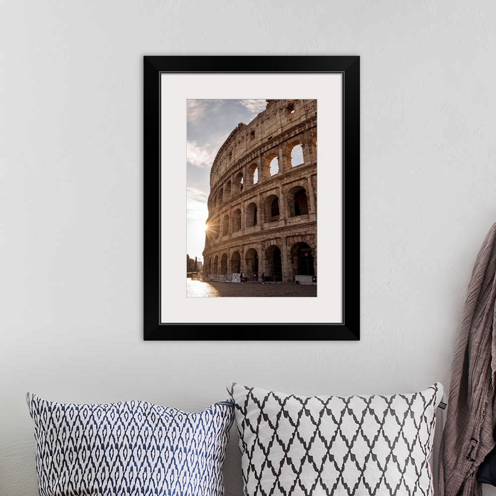 A bohemian room featuring Photograph of the sun shining on the side of the Colosseum in Rome on a beautiful day.