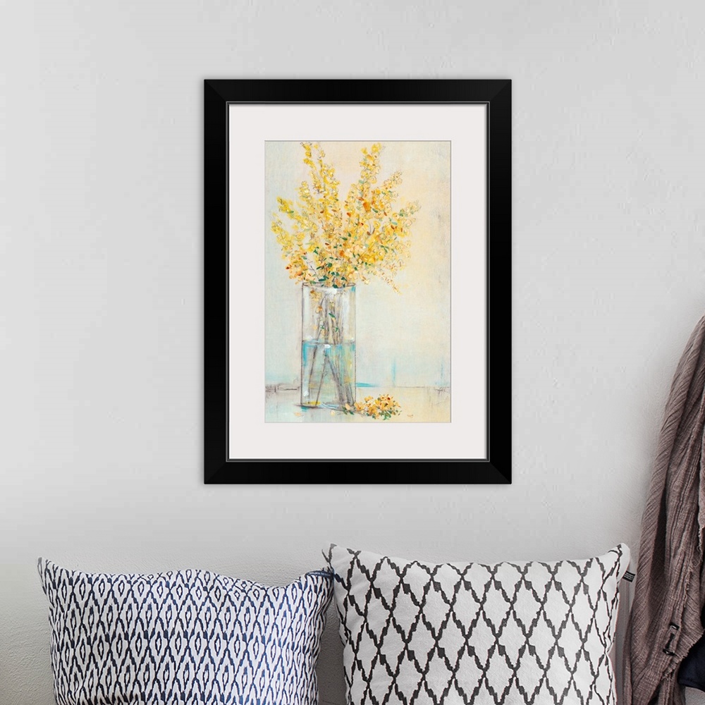 A bohemian room featuring Yellow flowers sitting in a rectangular glass vase.