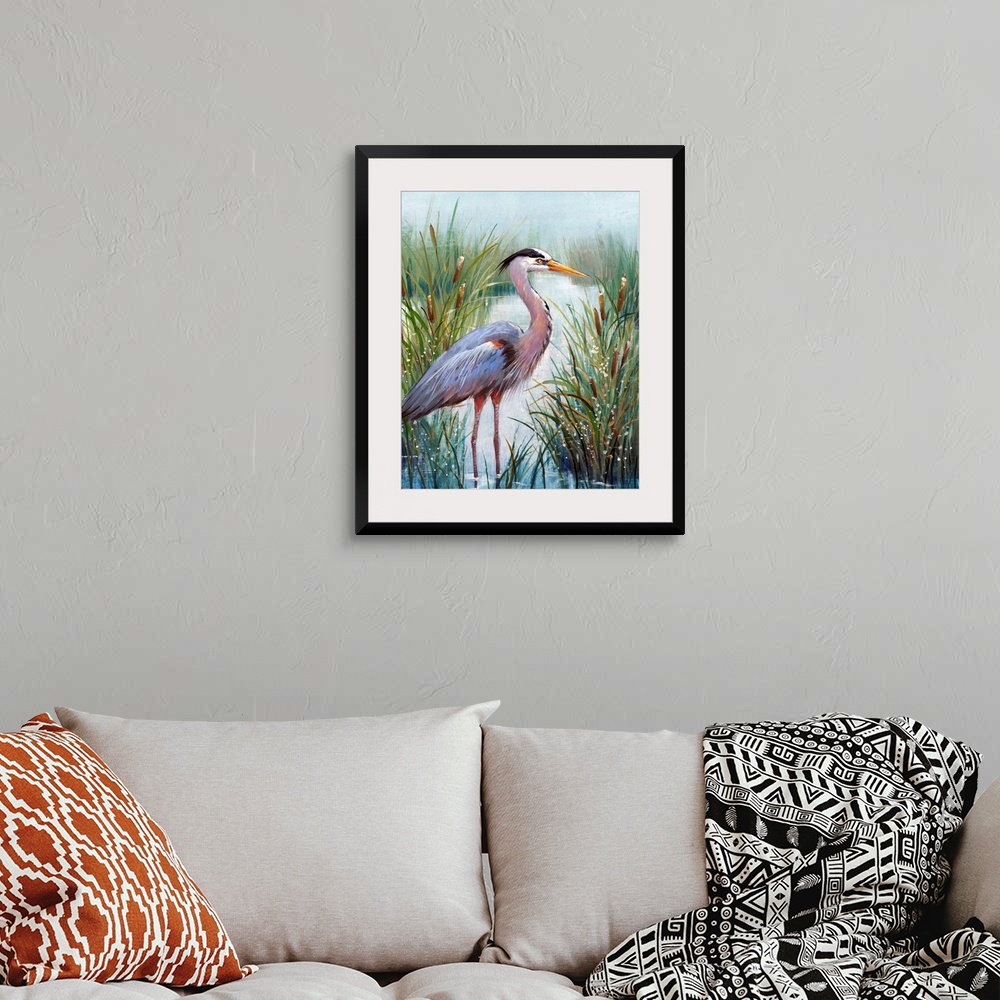 A bohemian room featuring In this contemporary artwork, a stoic heron wades in the water with tall grasses and cattails wor...
