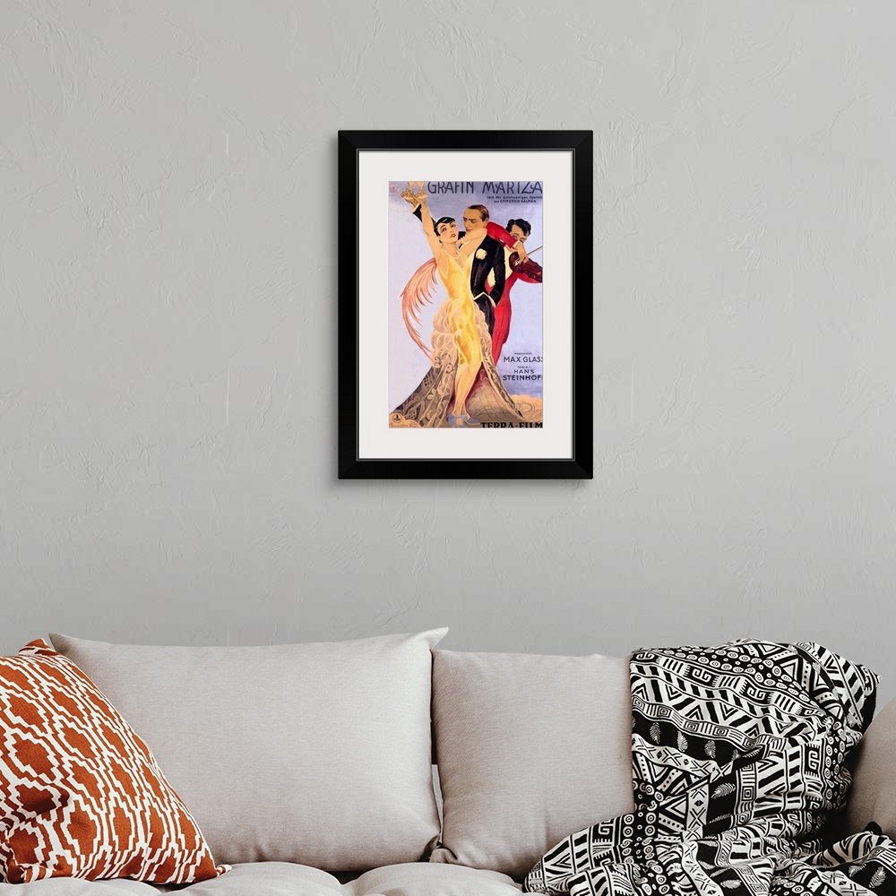 A bohemian room featuring Old entertainment advertising print.  A man and woman dressed in vintage formal wear are holding ...