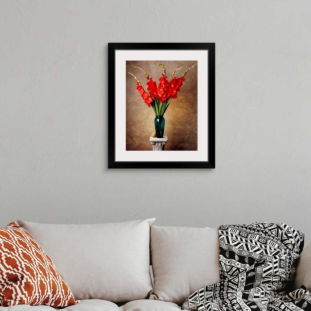 A bohemian room featuring Red gladiolas in a vase on a pedestal