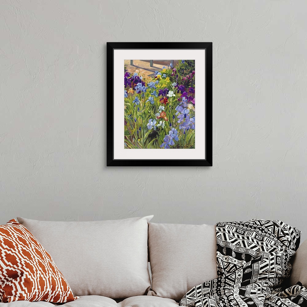 A bohemian room featuring Oil painting by Timothy Easton featuring colorful iris flowers blooming in a garden.