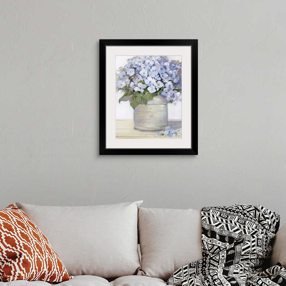 A bohemian room featuring Large still life painting of arranged lavender hydrangeas on a table.