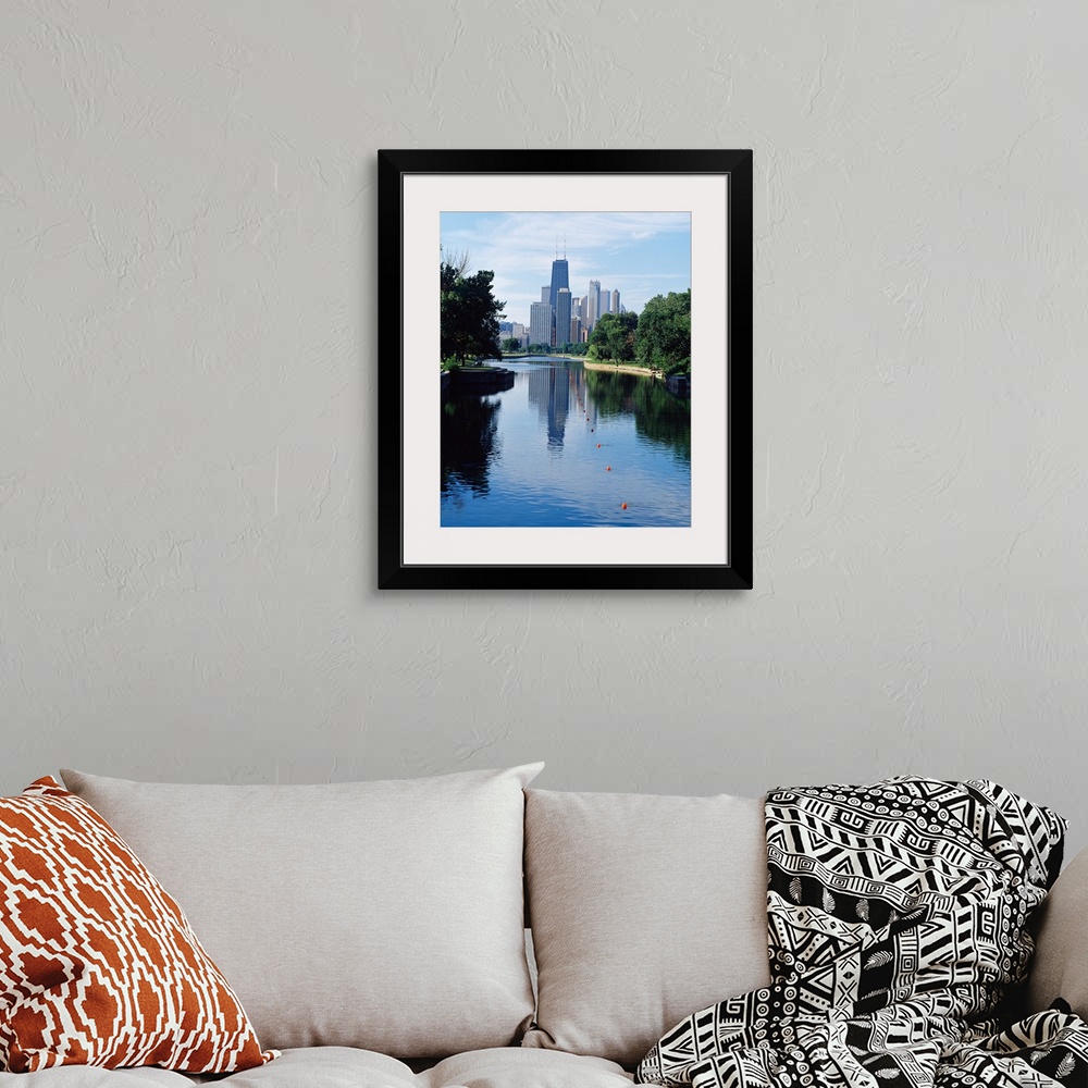 A bohemian room featuring Vertical panoramic photograph of buildings and skyline reflected in pond lined with trees.