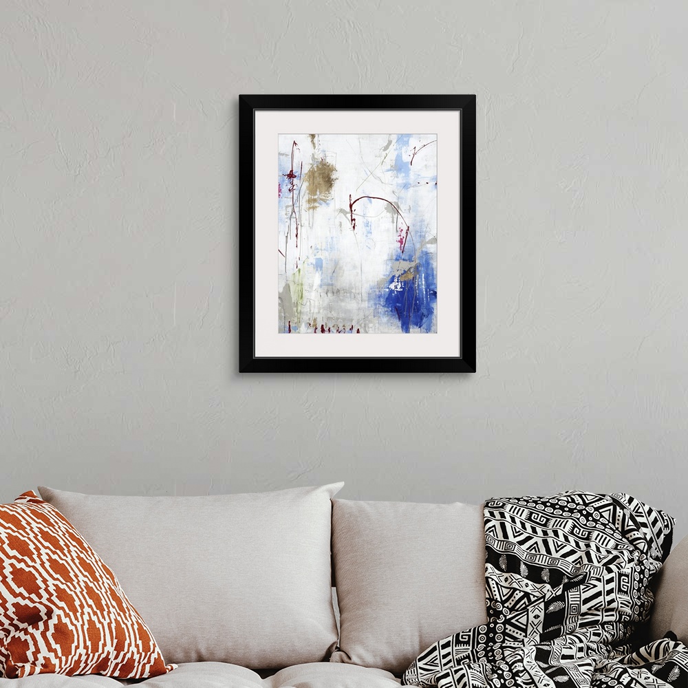 A bohemian room featuring Vertical abstract painting in gold and blue with textured drips of paint.