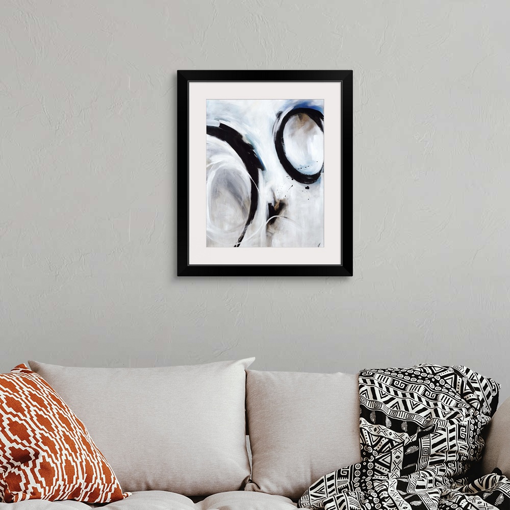 A bohemian room featuring Abstract artwork of strong black circular strokes over a soft blue and grey background.