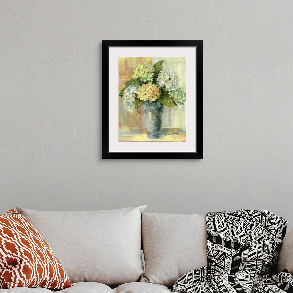 A bohemian room featuring Portrait, large still life painting of golden hydrangeas in a vase, sitting on a counter if front...