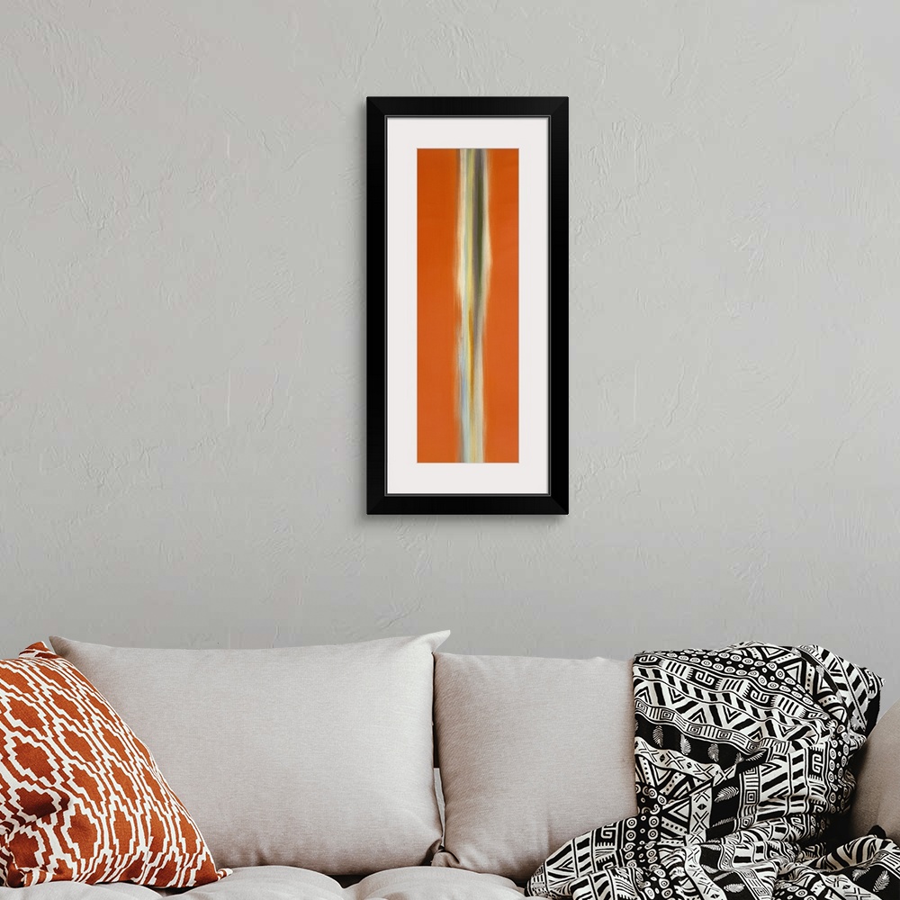 A bohemian room featuring A tall vertical piece of abstract artwork that has orange on both sides with a neutral colored li...