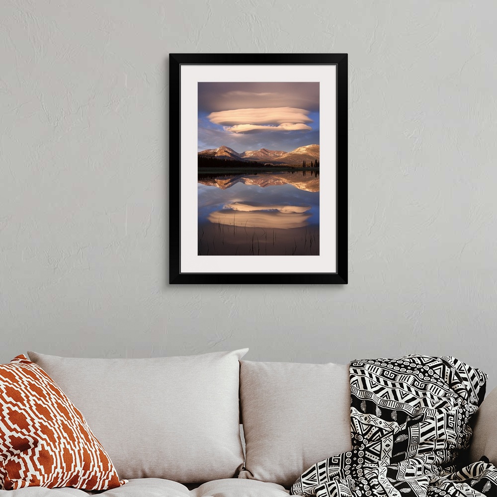 A bohemian room featuring Tall canvas photo art of billowing clouds above rolling hills reflected in the water.