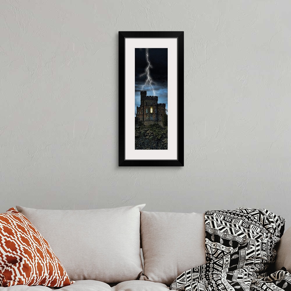 A bohemian room featuring Giant, vertical photograph of lightening striking a castle on a hill, a single light can be seen ...