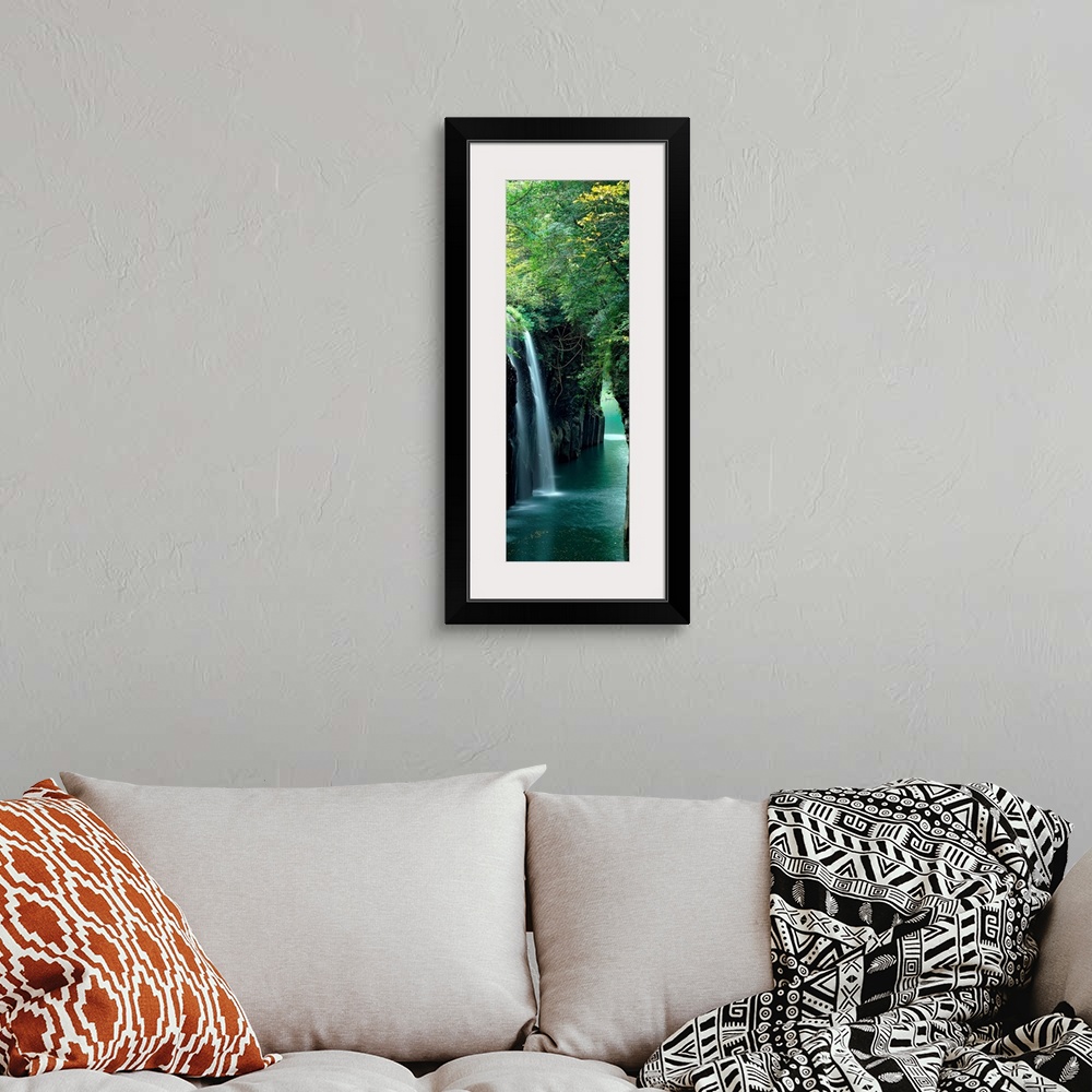 A bohemian room featuring Vertical outdoor shot of a forest, river, and waterfall taken with time-lapsed photography.
