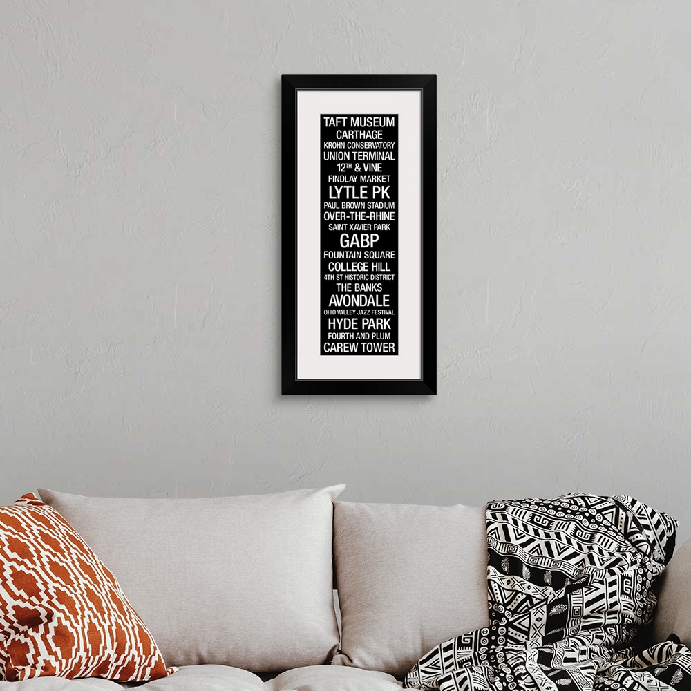 A bohemian room featuring Typographic artwork showcasing some beloved city landmarks on a narrow, vertical wall art.