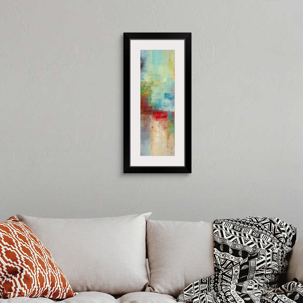 A bohemian room featuring A narrow piece of abstract artwork that is filled with mostly cool blocks of colors and a pop of ...