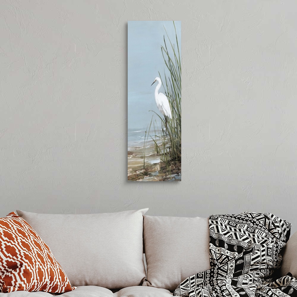A bohemian room featuring Tall panel painting of an egret walking on the shore with tall beach grass.