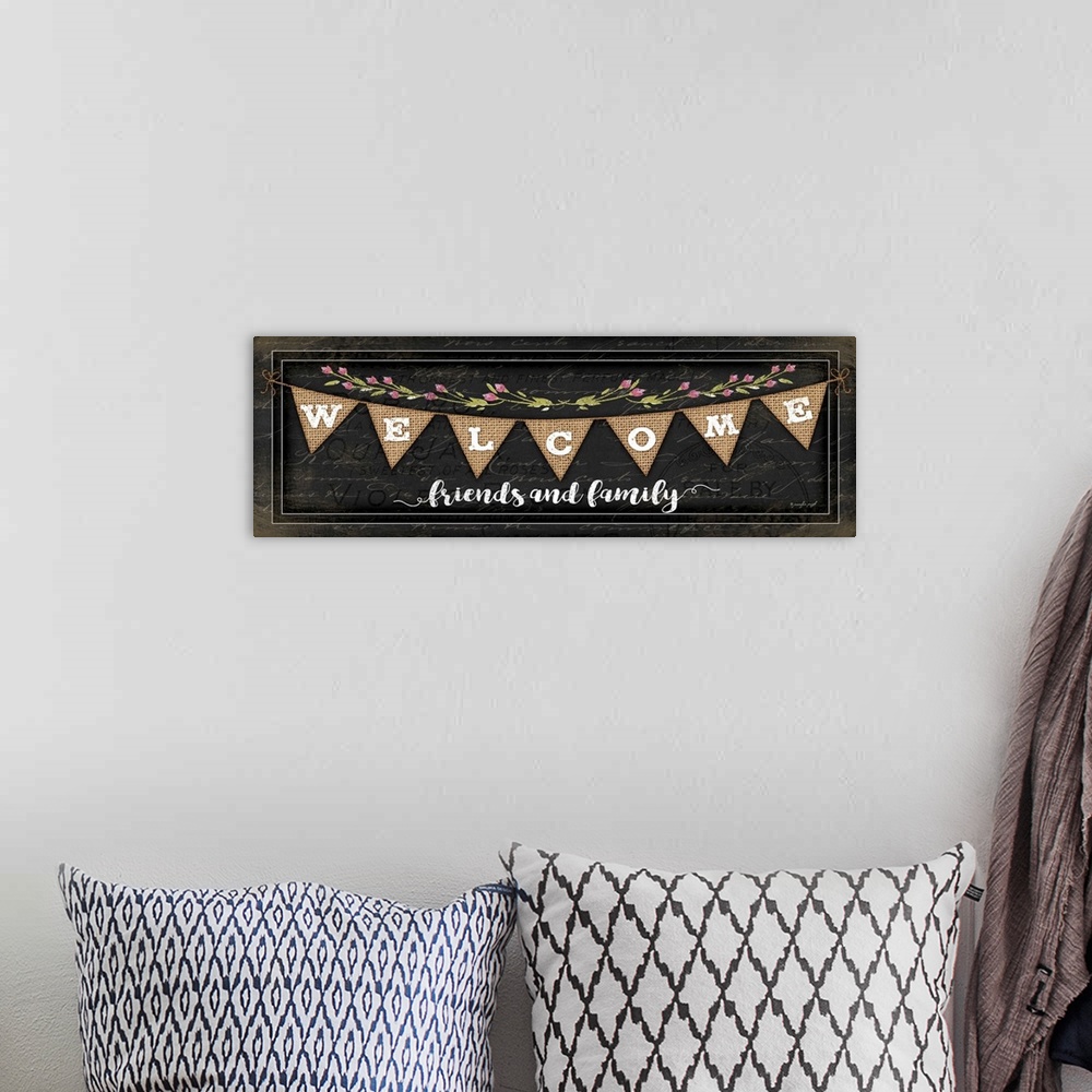 A bohemian room featuring "Welcome Friends and family" on a bunting banner with flowers.