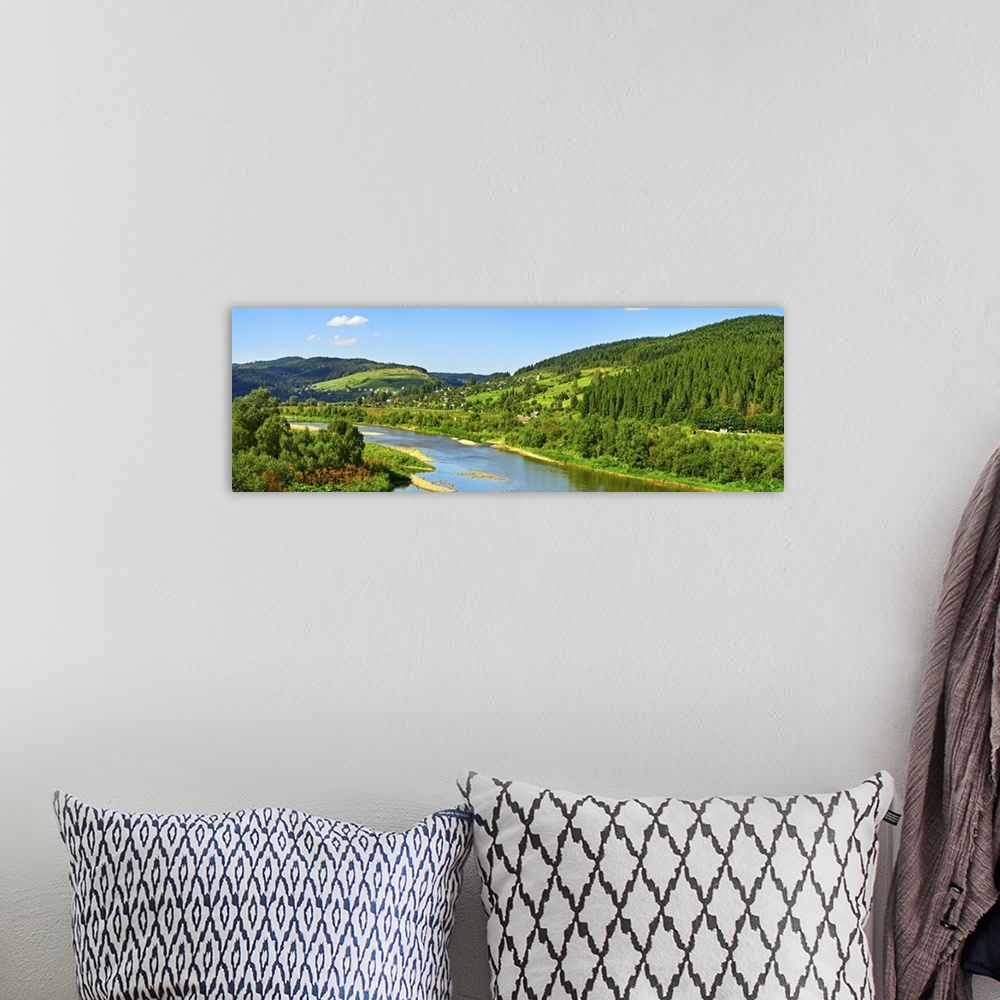 A bohemian room featuring Carpathian mountain summer landscape with river, sky, and clouds.
