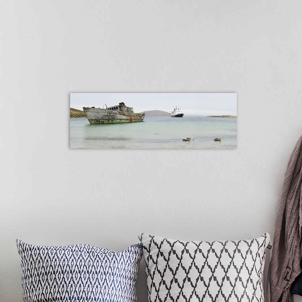 A bohemian room featuring Abandoned shipwreck along shoreline with new cruise ship, Falkland Islands
