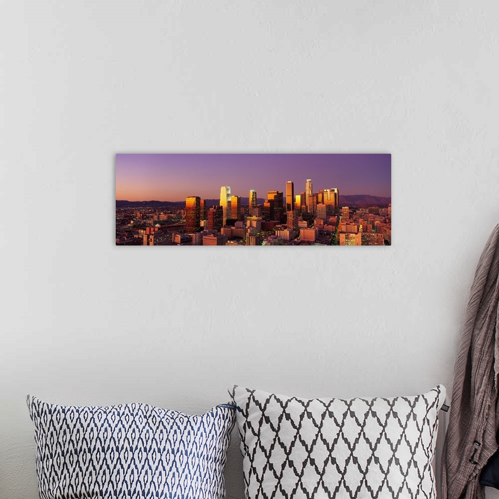 A bohemian room featuring Panoramic photograph of west coast city skyline at dusk.  The buildings and skyscrapers are lit u...