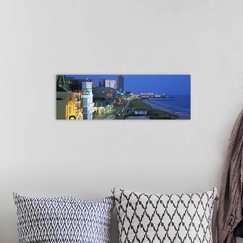 A bohemian room featuring Panoramic photograph of skyline along boardwalk and oceanfront at dusk.