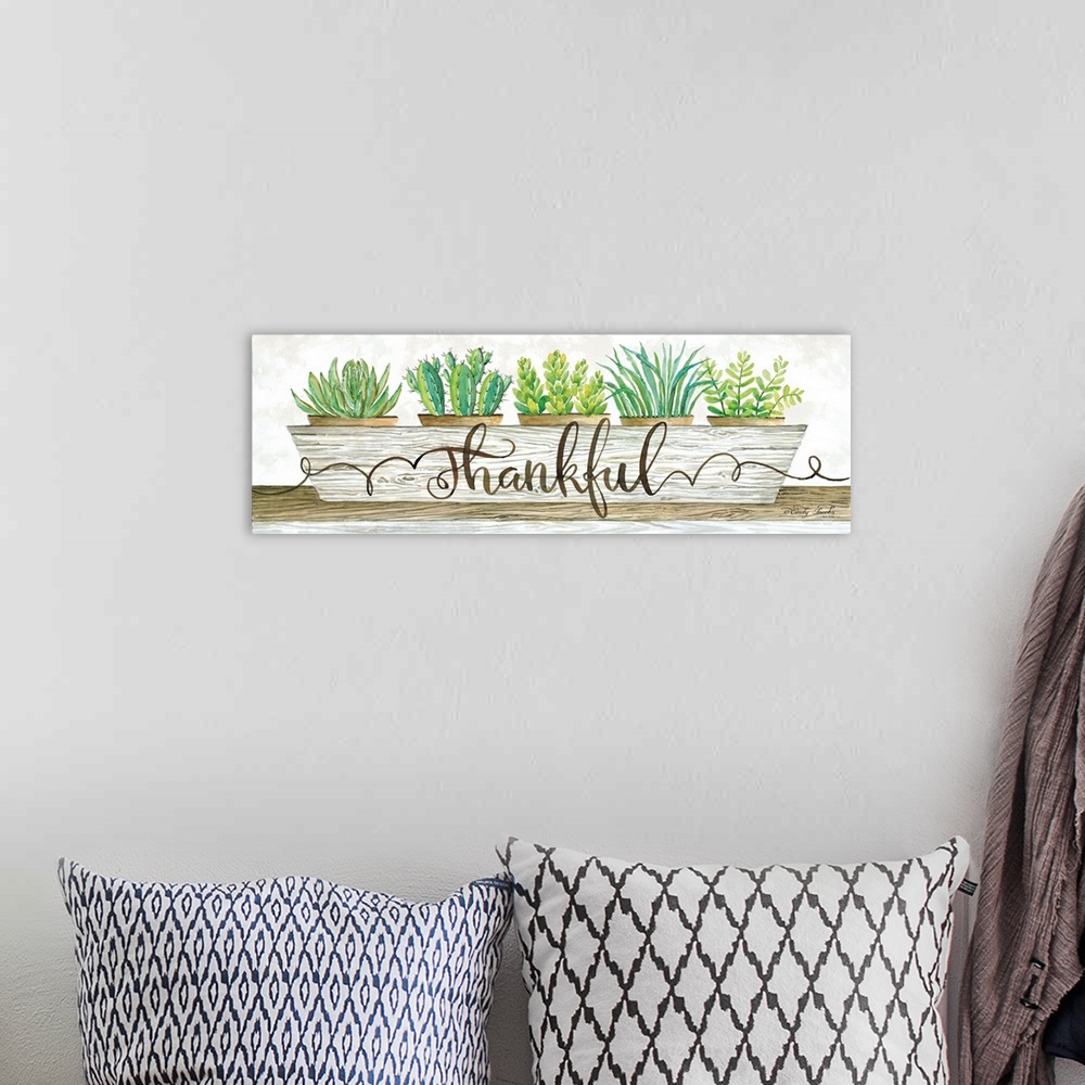 A bohemian room featuring The word, thankful, is placed over a planter filled with bright green succulents and cacti.