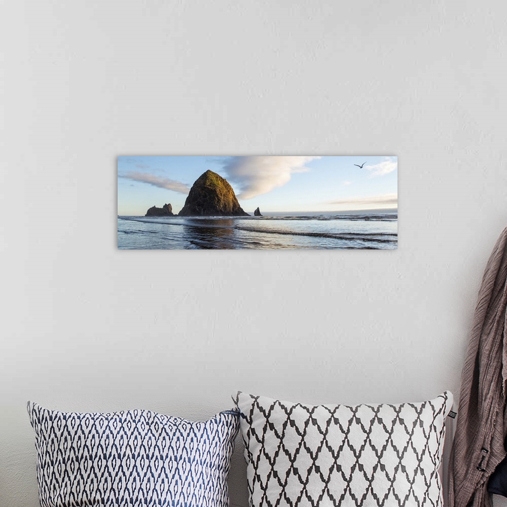 A bohemian room featuring Panoramic photograph of Haystack Rock with a bird flying in the sky at Cannon Beach.