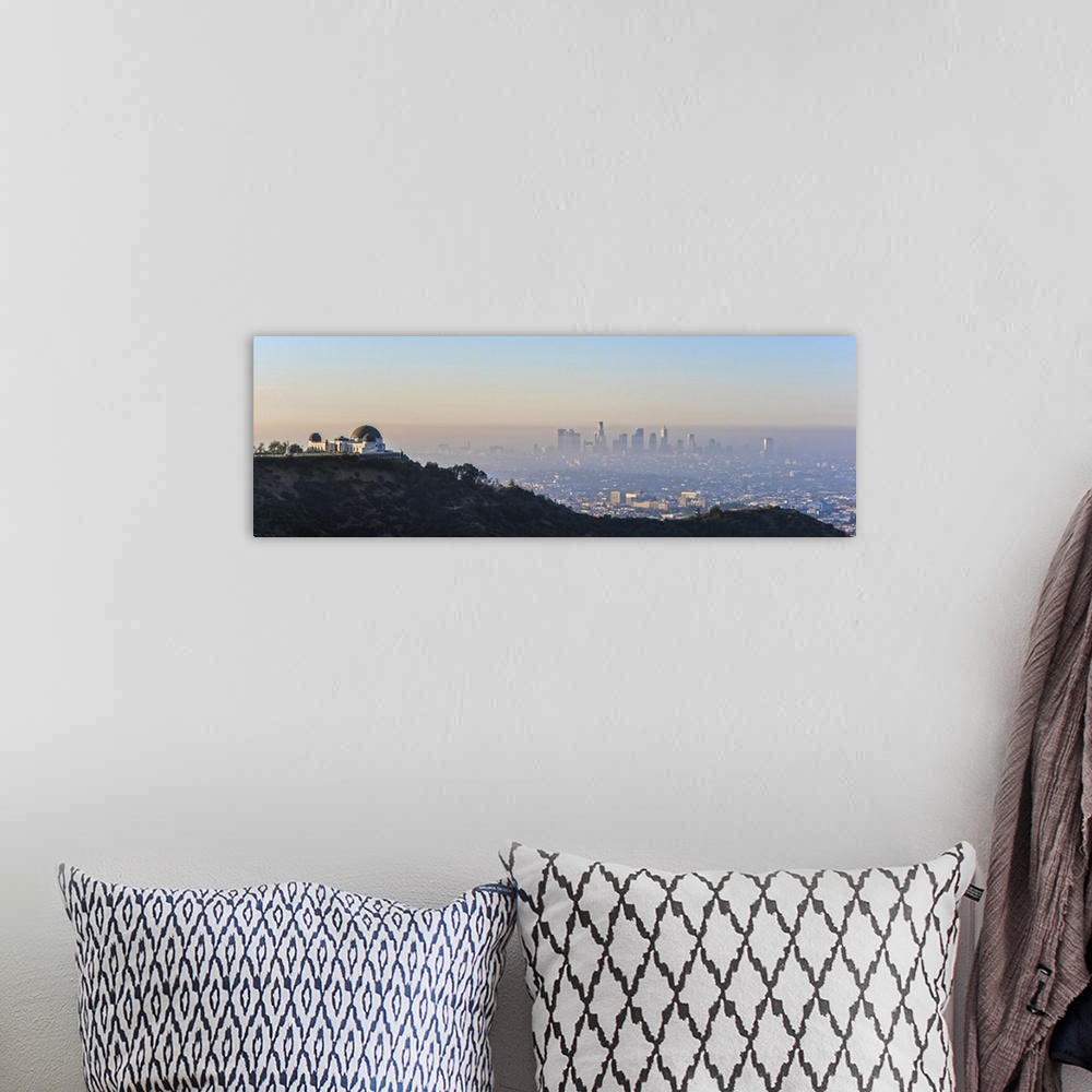 A bohemian room featuring Panoramic photograph of the hazy Los Angeles skyline with Griffith Observatory on the left in the...