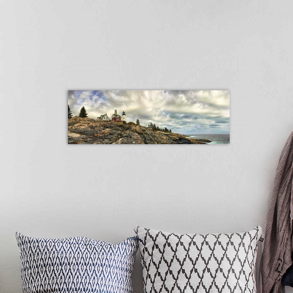 A bohemian room featuring Panoramic photography of Pemaquid Lighthouse on the rocky coast under stunning clouds.