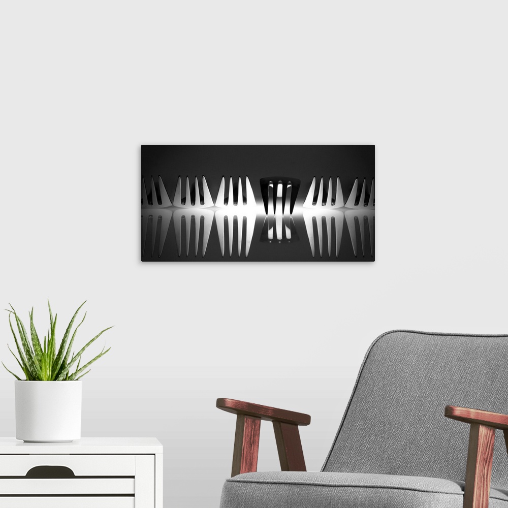 A modern room featuring Abstract image of a row of forks with light reflecting from below with one turned upside down.