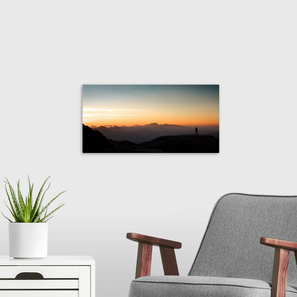 A modern room featuring Mountaineer looking at the sunrise.