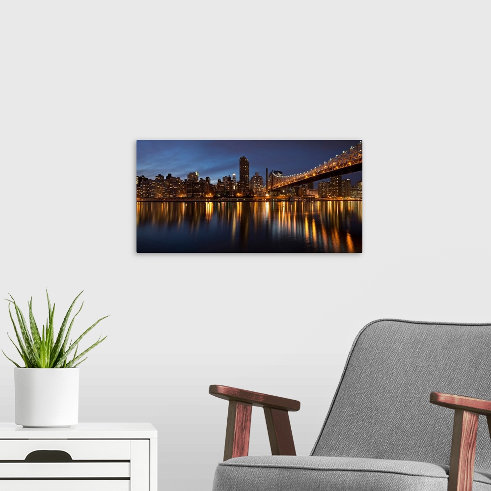 A modern room featuring City lit up at night, Queensboro Bridge, Roosevelt Island, Manhattan, New York City, New York Sta...