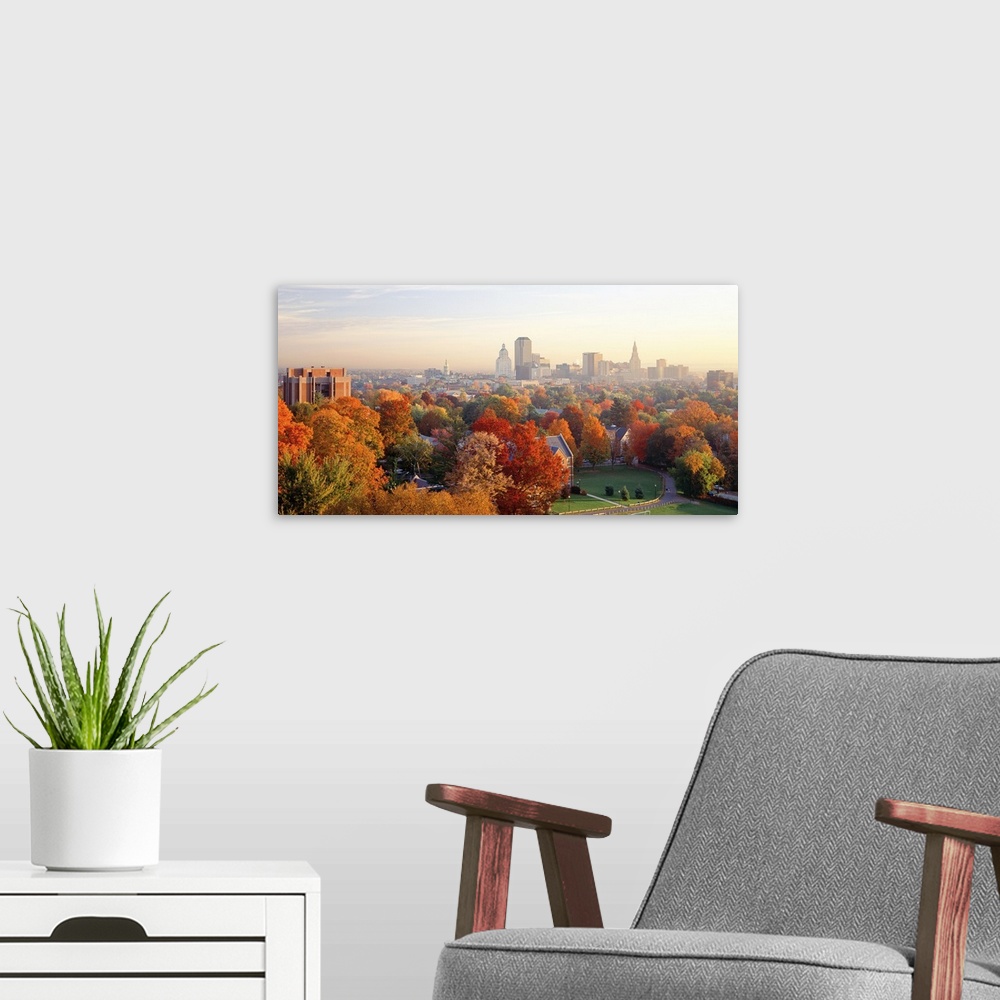 A modern room featuring Fall foliage in bright colors with views of the city of Hartford, CT in the background.