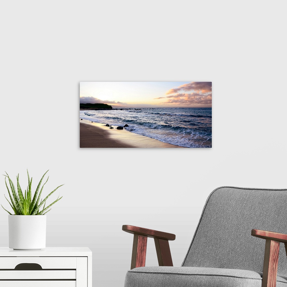 A modern room featuring A photograph of a pink and orange sunset on the beach.