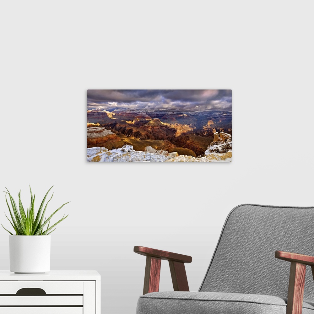 A modern room featuring Vista of the Grand Canyon in Arizona under a blanket of snow and dark storm clouds.